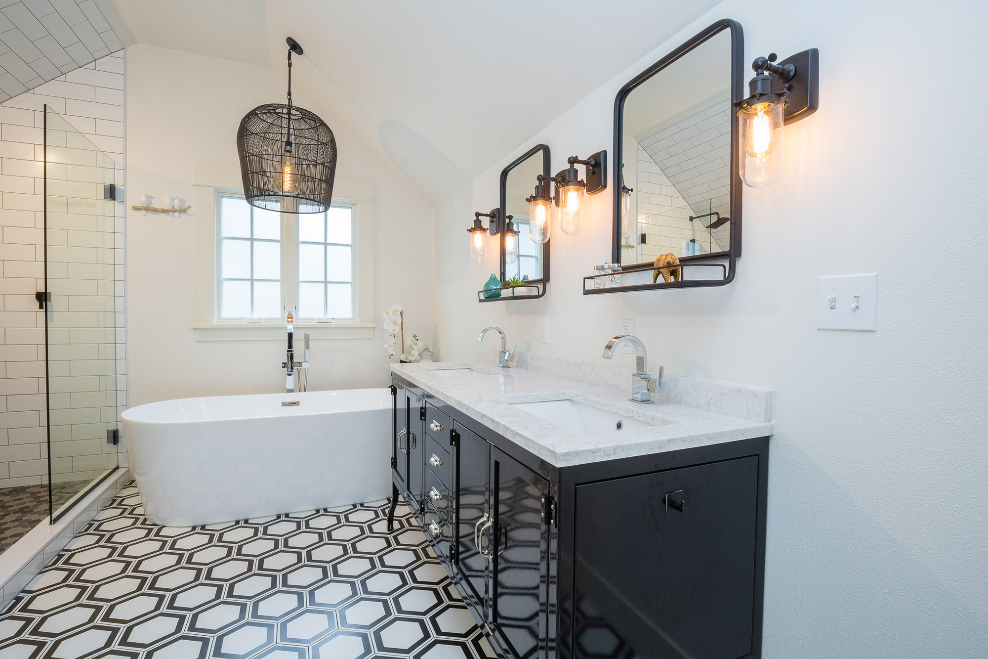 Double vanity with dark cabinet and freestanding soaking tub under wicker pendant light, vaulted primary bath, Carolina Primary Suite addition by Tweto Architecture, SW Portland