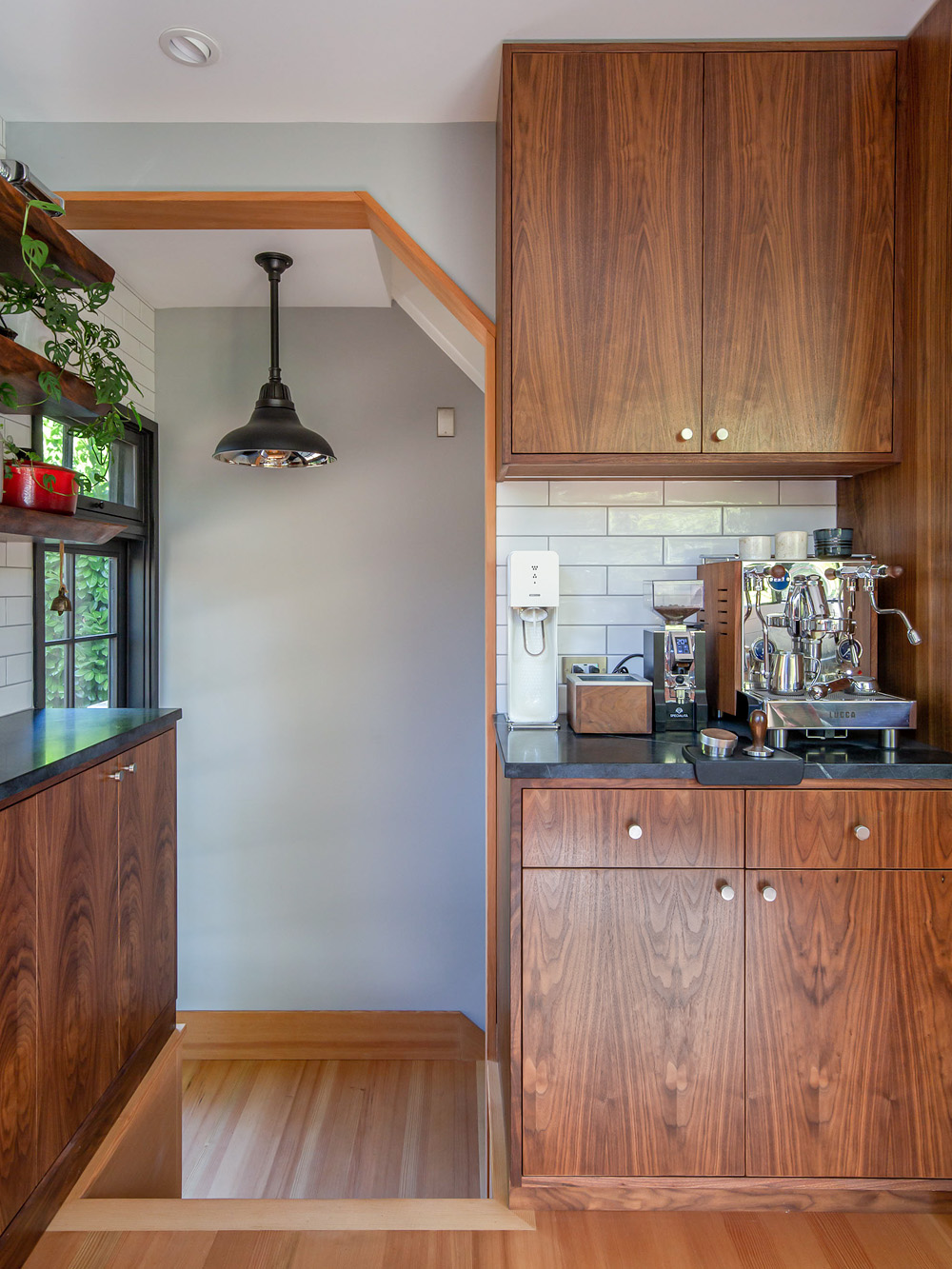 Dedicated coffee station with espresso machine set into walnut cabinetry beside the stair opening, Concordia Kitchen by Tweto Architecture