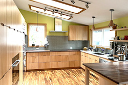 Kitchen with light wood cabinets, skylights and a wood-topped peninsula, SW 52nd remodel in Portland by Tweto Architecture