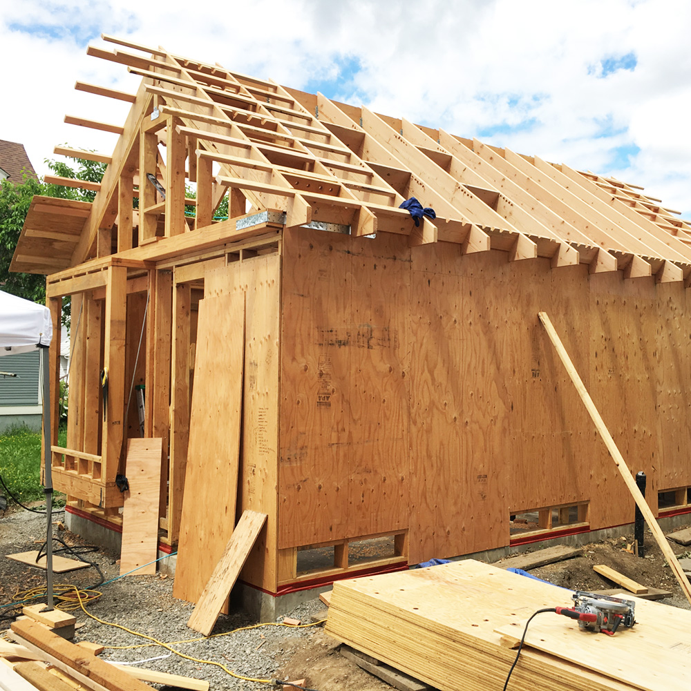 ADU framing under construction, showing wood structure and gable roof taking shape, by Tweto Architecture