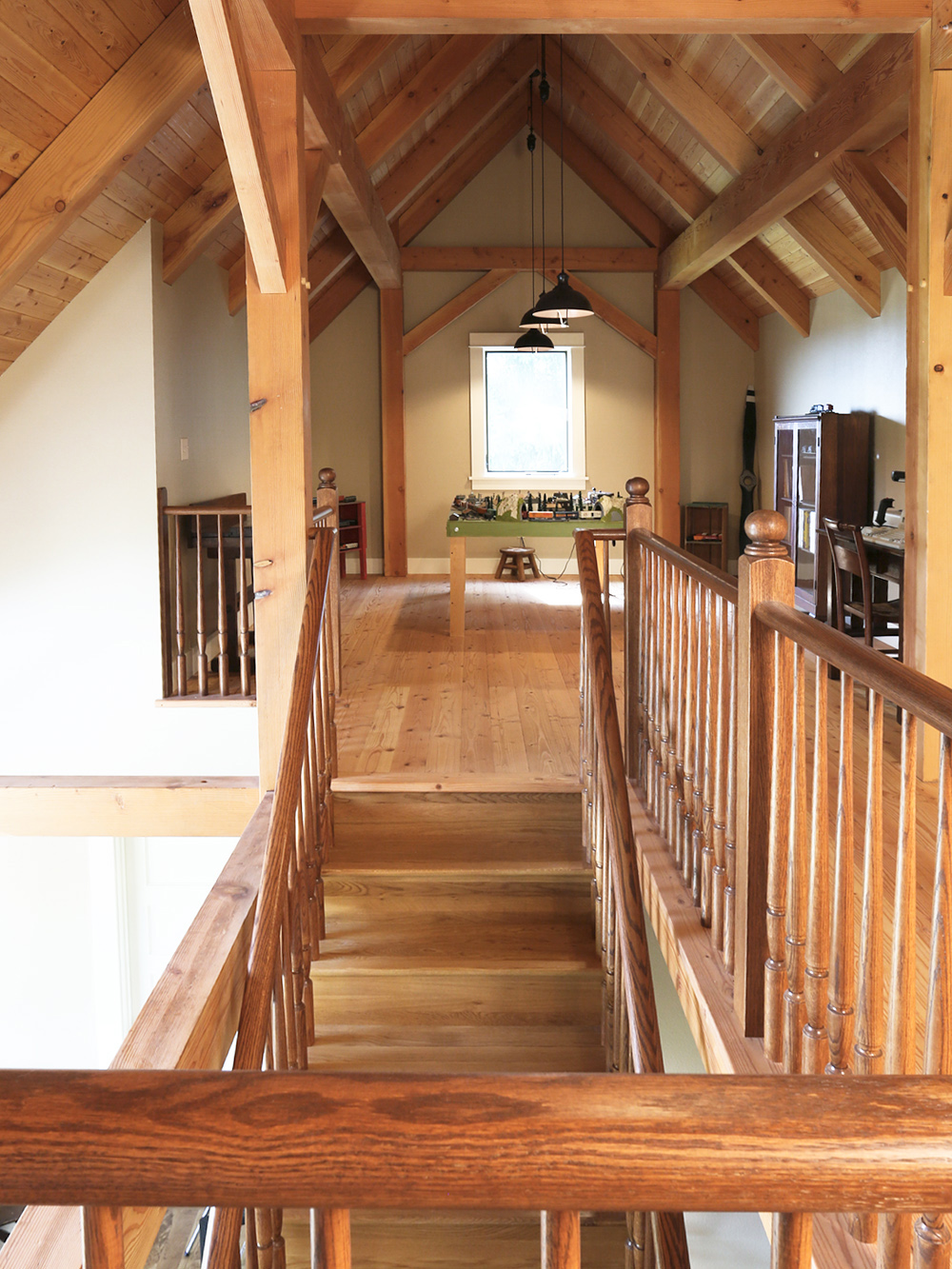 Loft level looking toward hobby table and model train, open railing at stair head, vaulted Douglas Fir decking ceiling, North Plains Timber Frame by Tweto Architecture