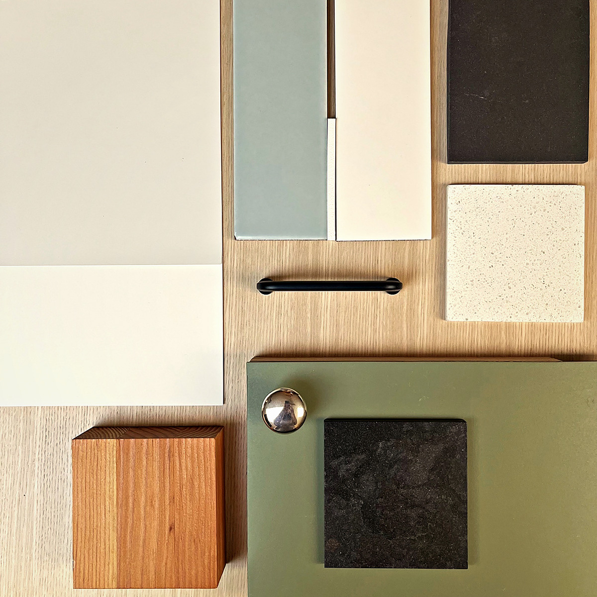 Interior design materials flatlay with cabinet door samples, paint swatches, tile, countertop, and hardware selections