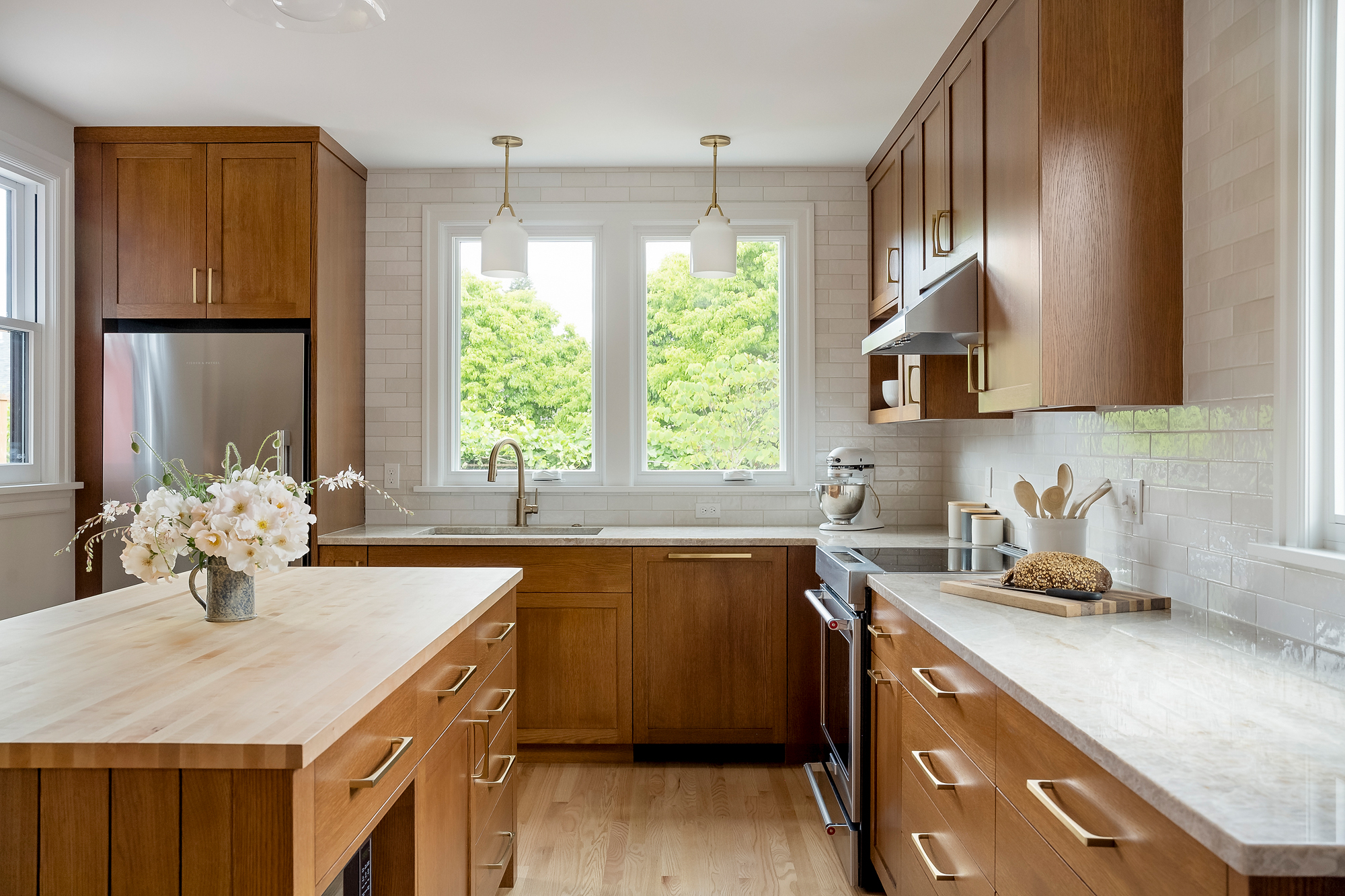 Sink moved to the east wall below new windows looking to the backyard, with white oak island and quartzite counters, Rose City Kitchen by Tweto Architecture