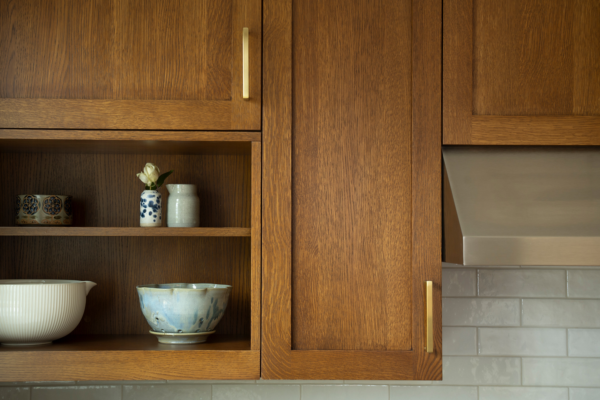 Detail of rift-sawn white oak cabinets with brass pulls, open display shelf, and zellige tile backsplash, Rose City Kitchen by Tweto Architecture
